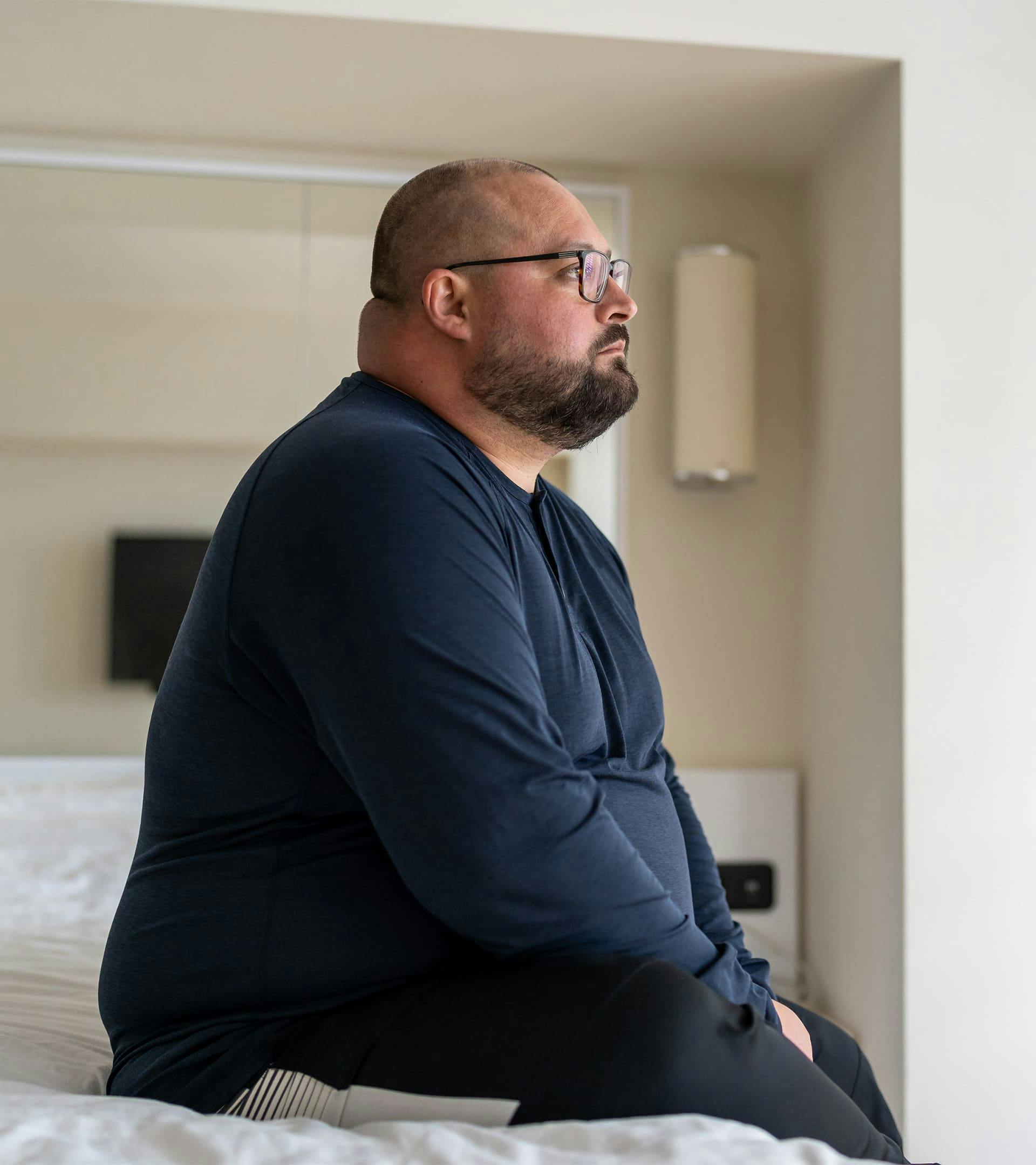 Man sitting on the side of a bed