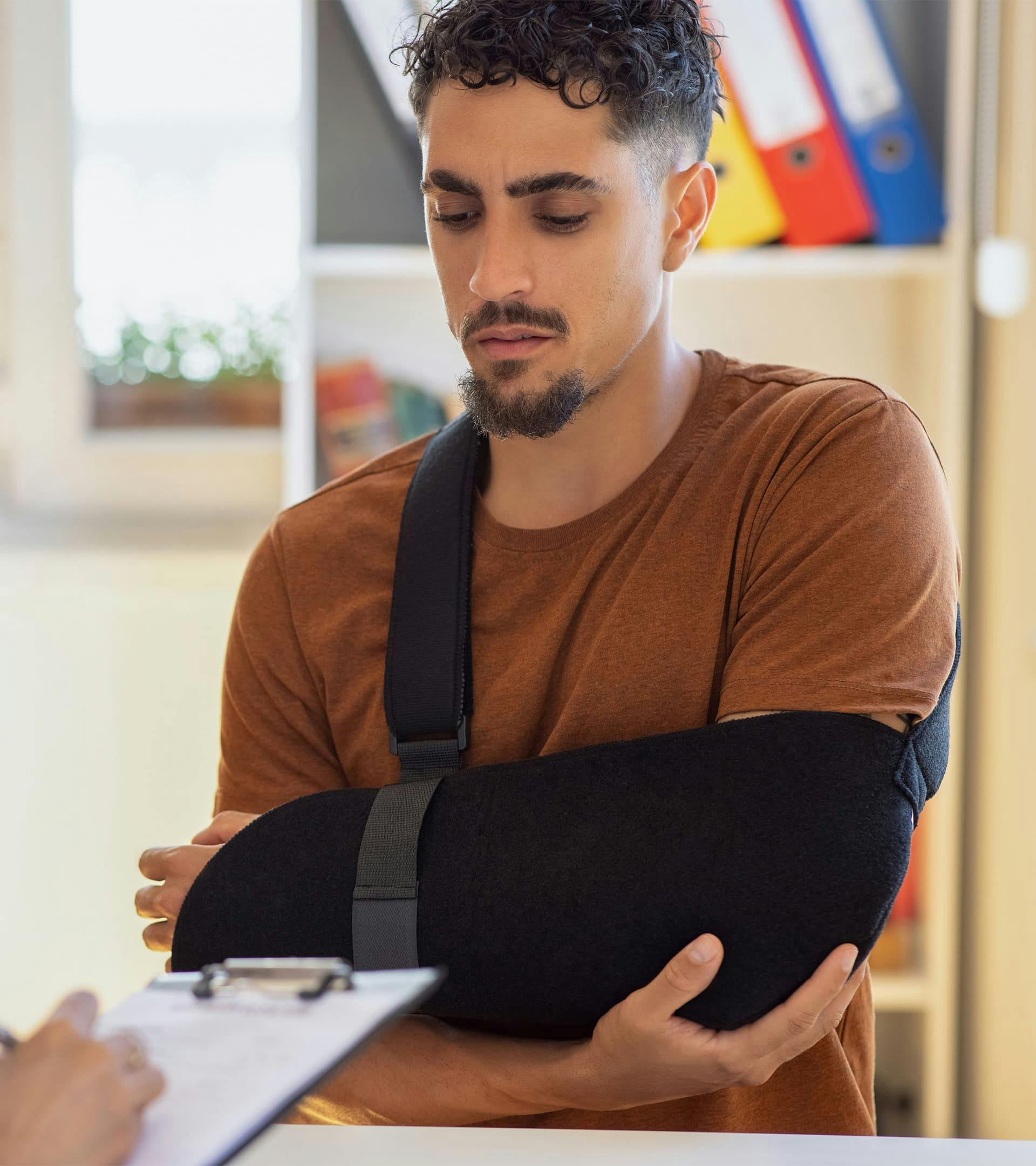 Man holding his elbow while its in a sling