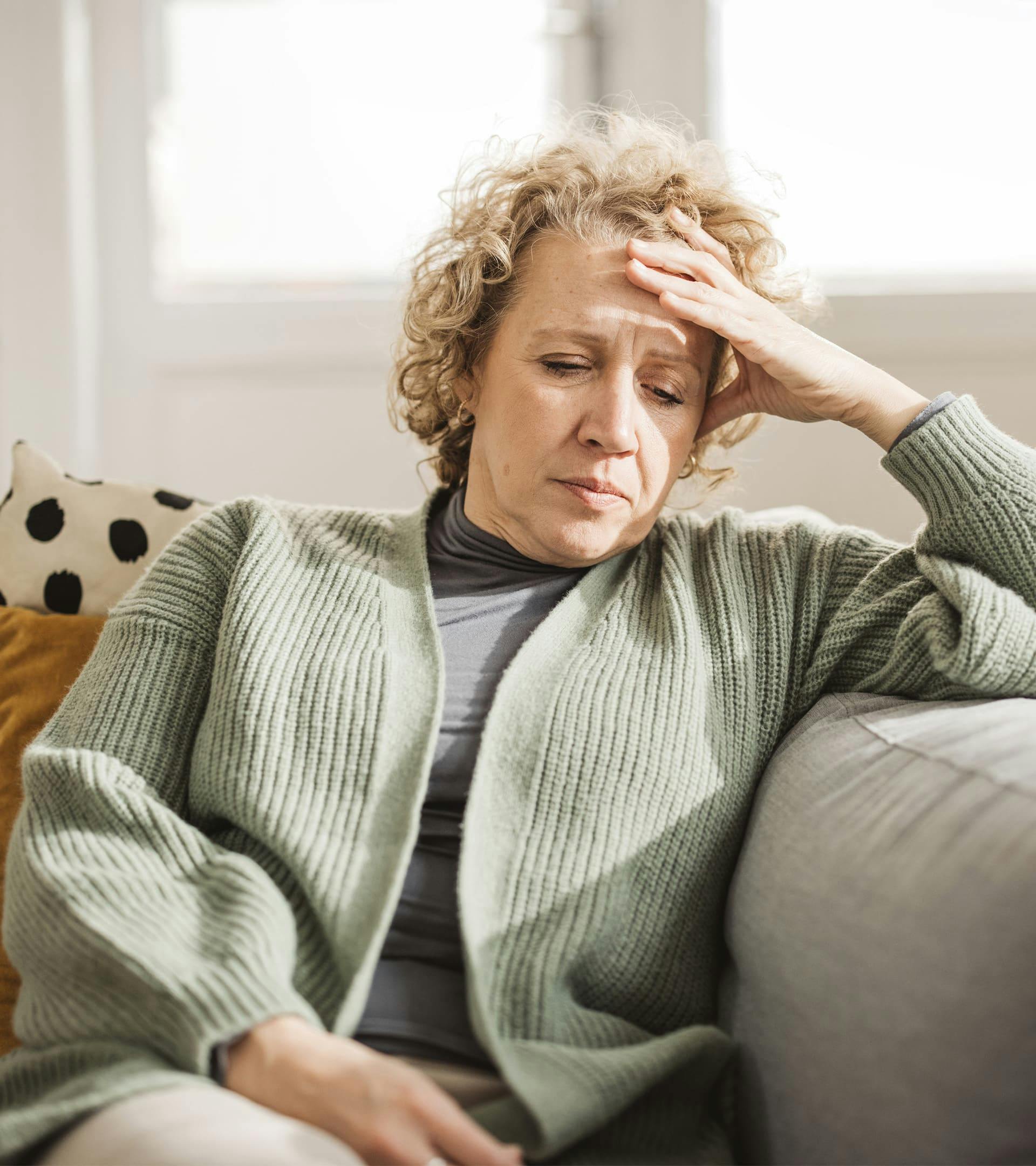 Woman looking upset with head in hand