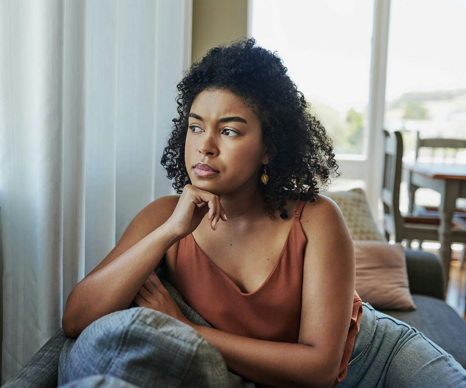 Woman looking outside resting chin on hand