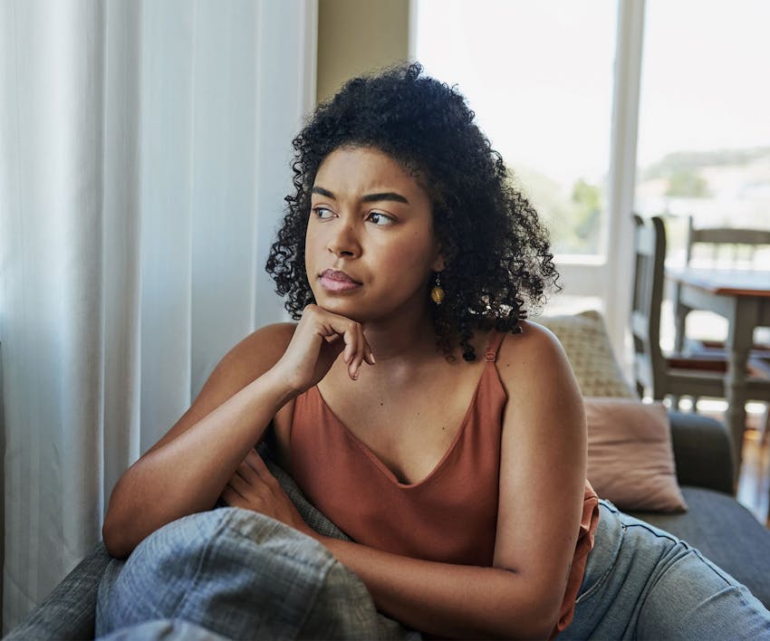 Woman looking outside resting chin on hand