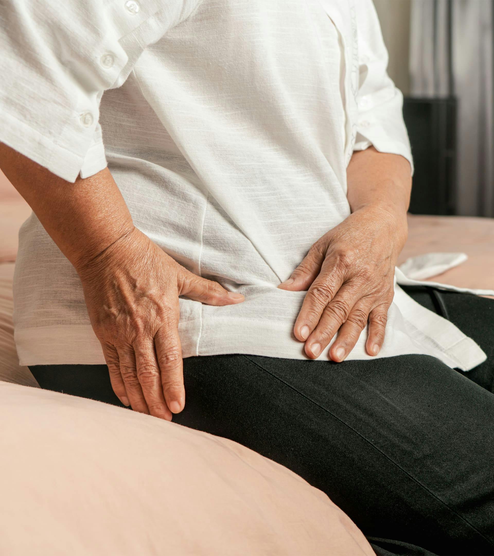 Person holding their hip in pain