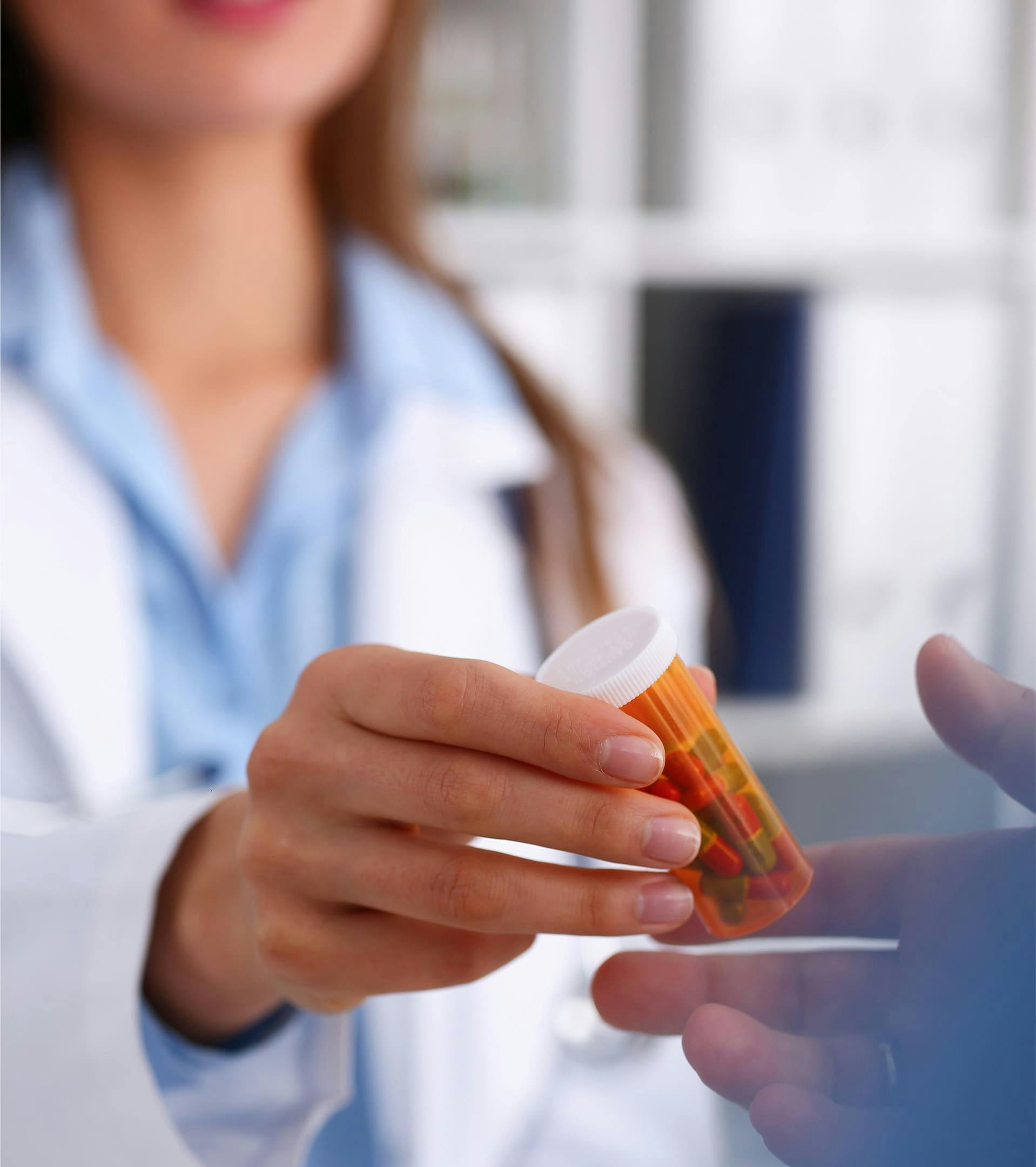 Nurse handing pill bottle