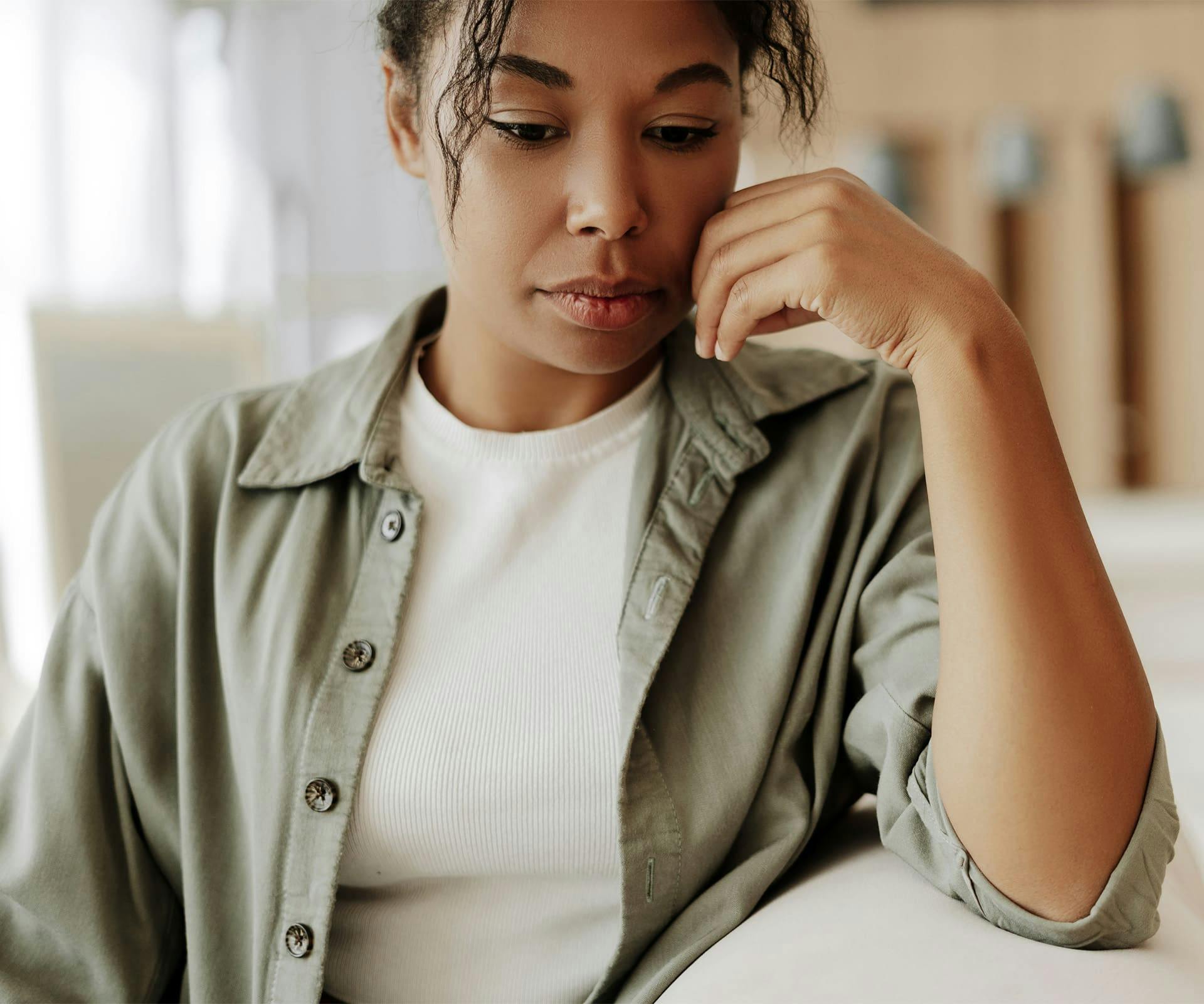 Woman sitting with hand up by cheek