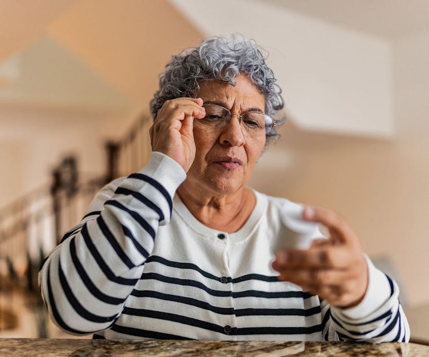 Woman looking at something and touching glasses