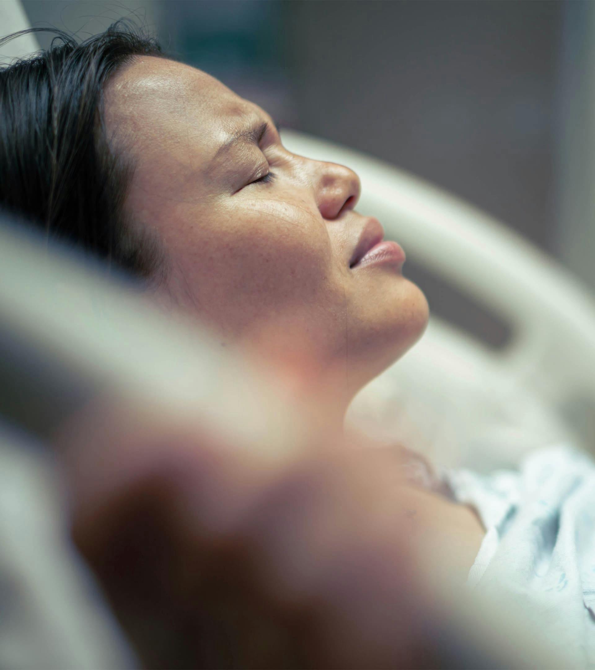 Woman in pain on a hospital bed