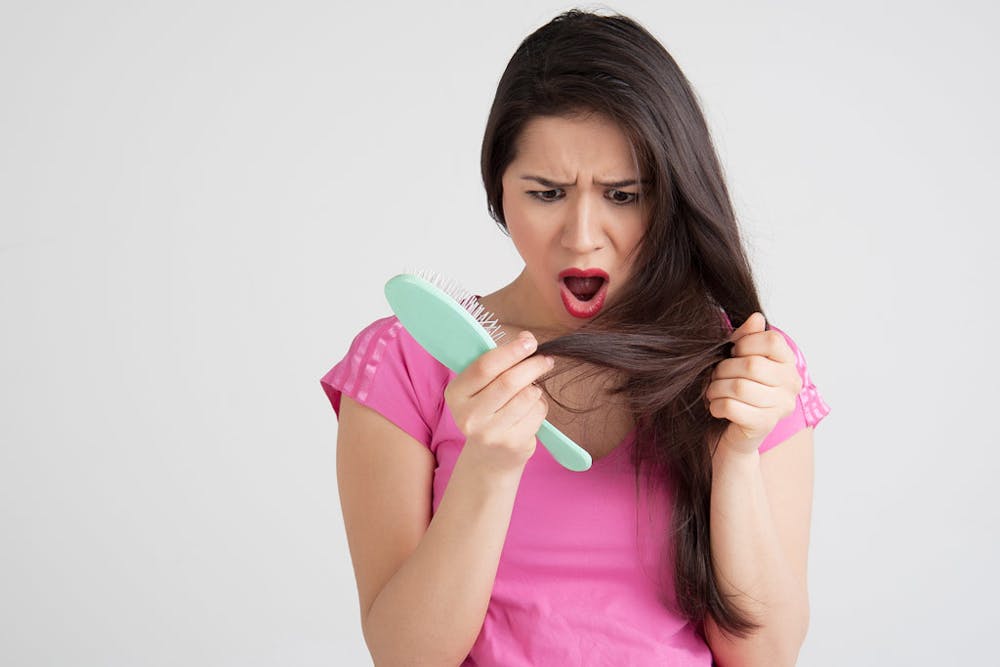 shocked-woman-losing-hair-on-hairbrush