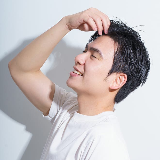 man leaning his head back and touching his forehead