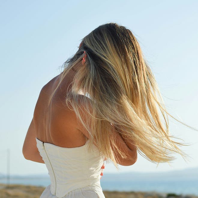woman facing away with her hair flowy in the wind