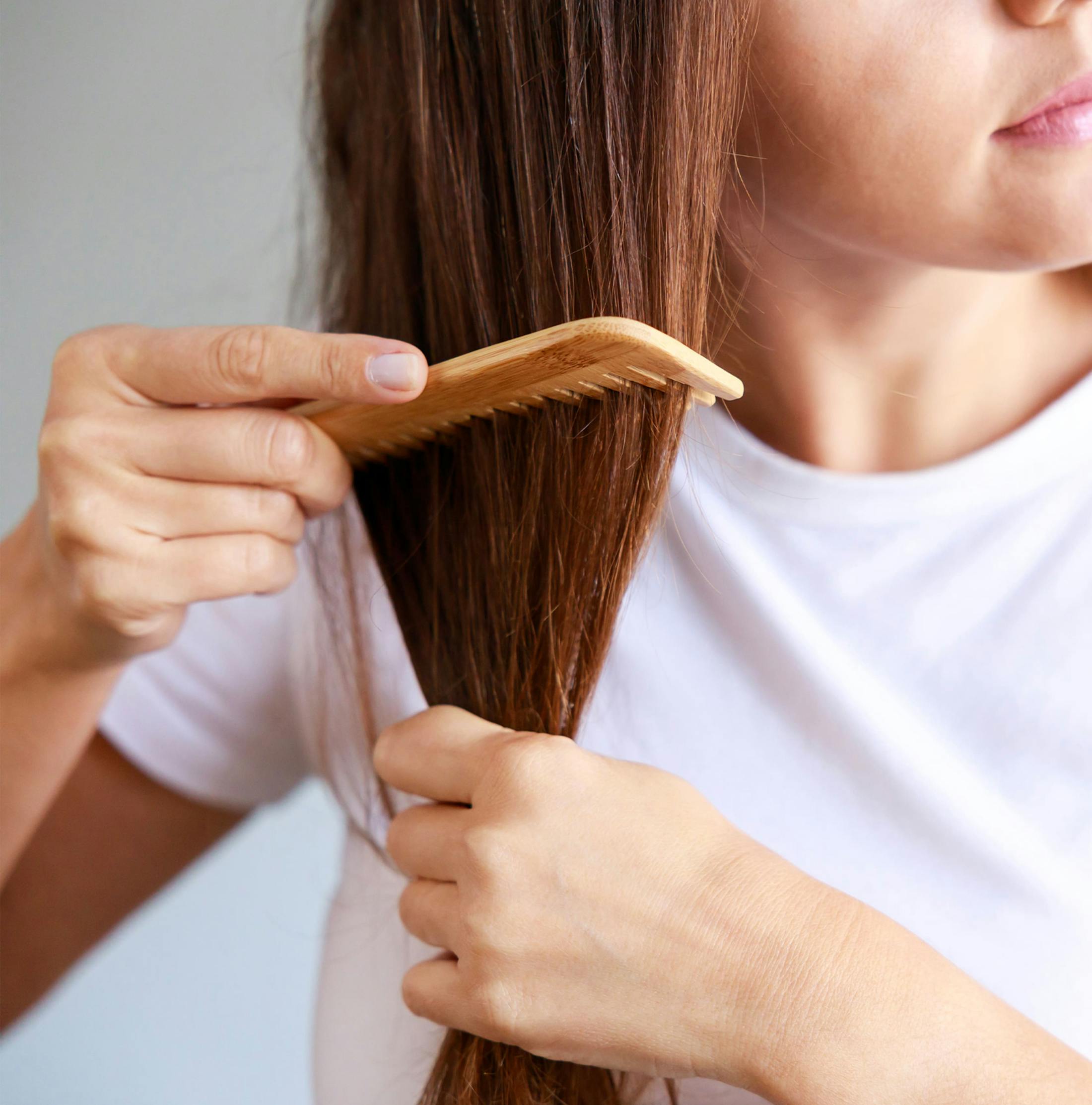 close up on woman combing her hair