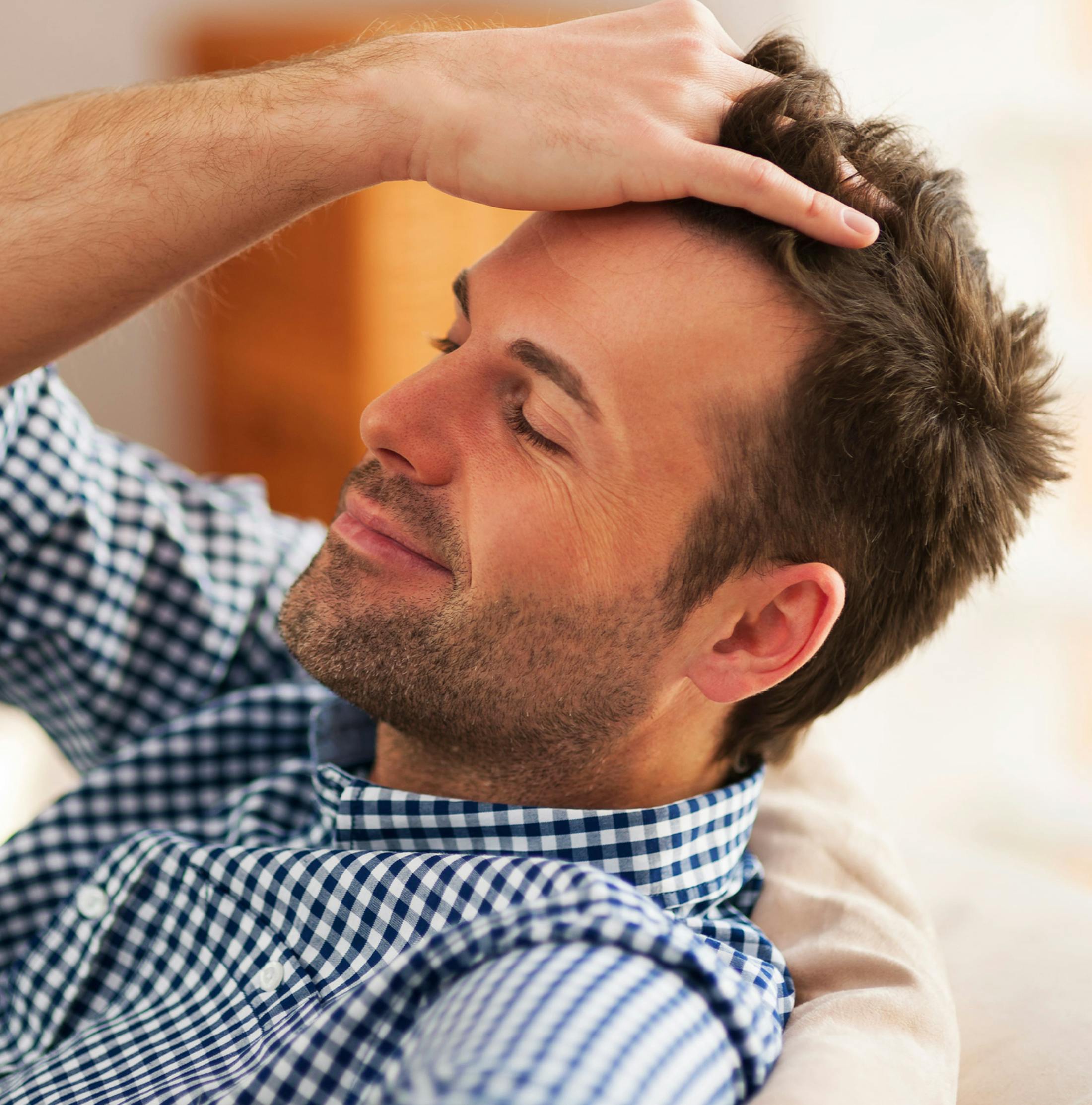 man combing through his hair with his hands
