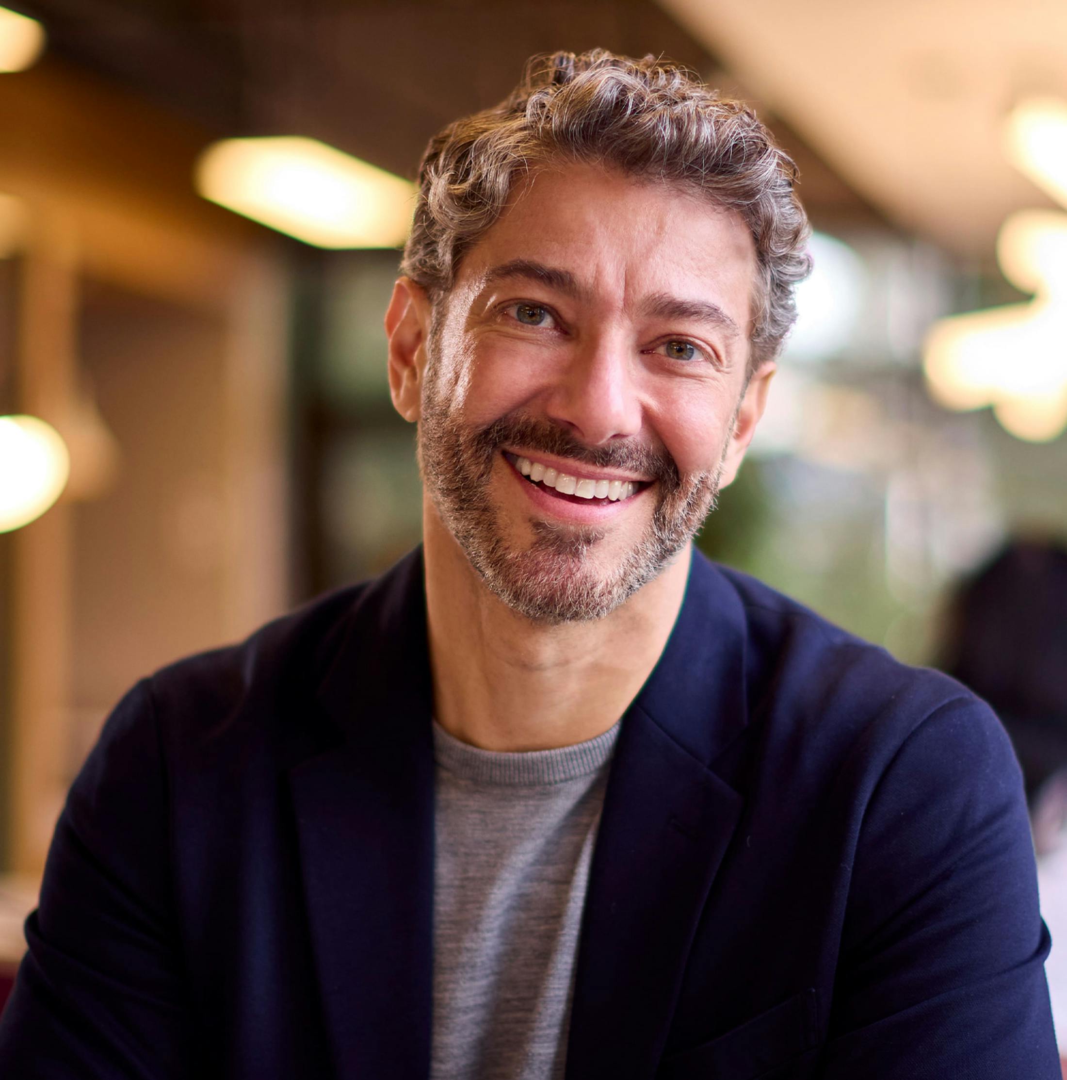 man smiling with curly short hair