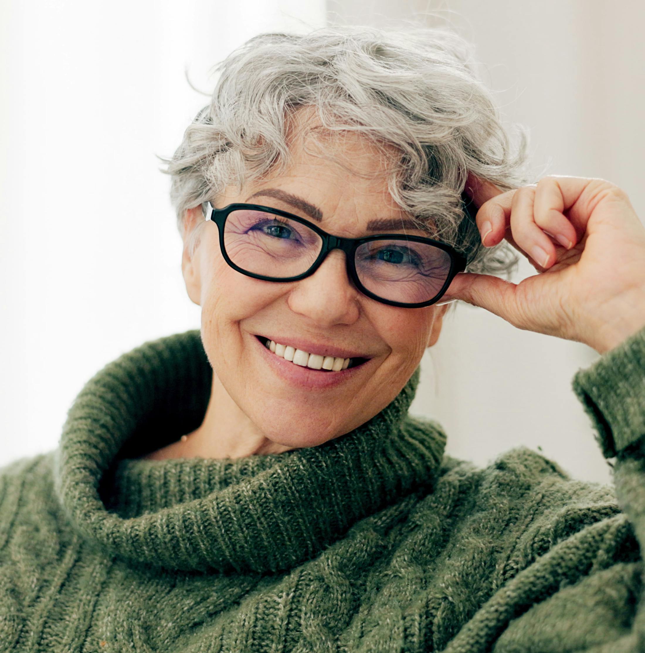 older woman smiling with thick, green sweater on
