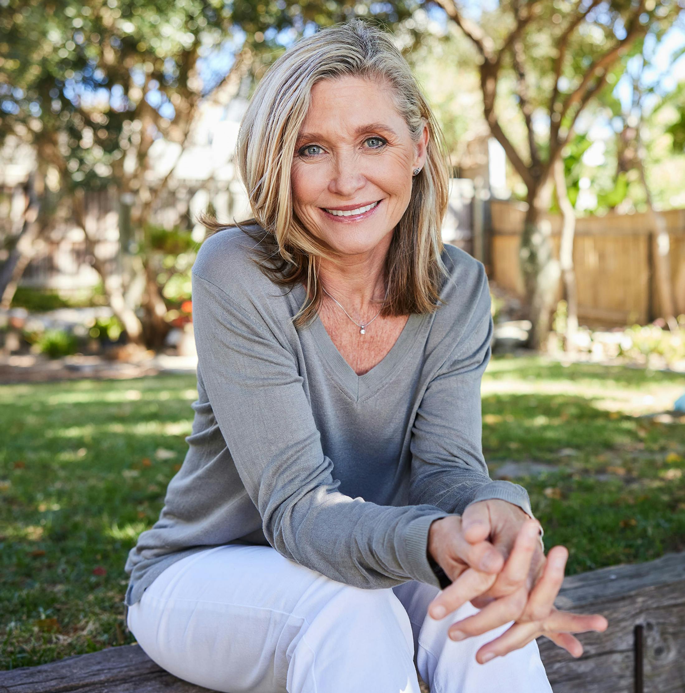 woman sitting on wooden bench and smiling