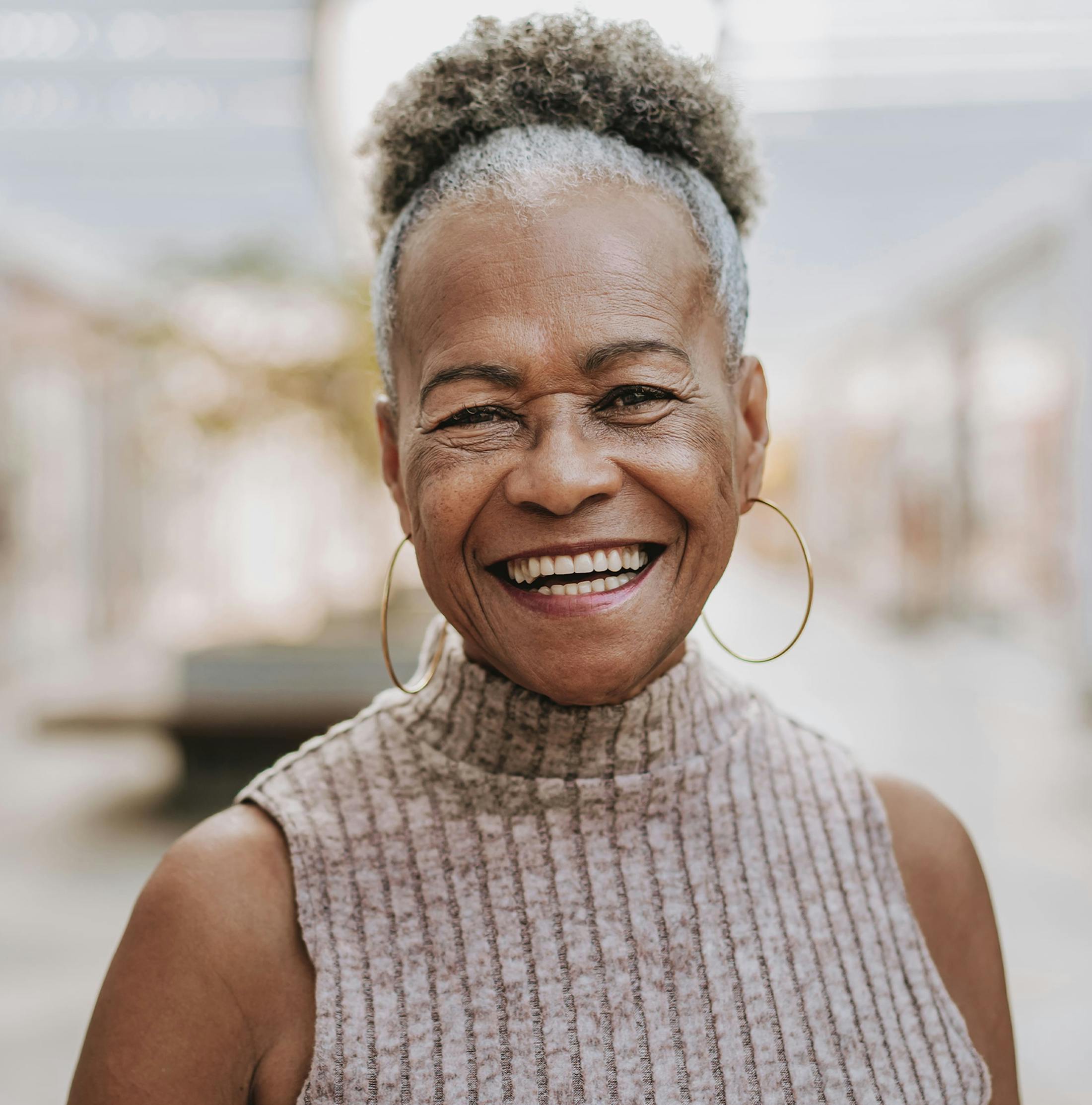 older woman smiling with her hair in a bun