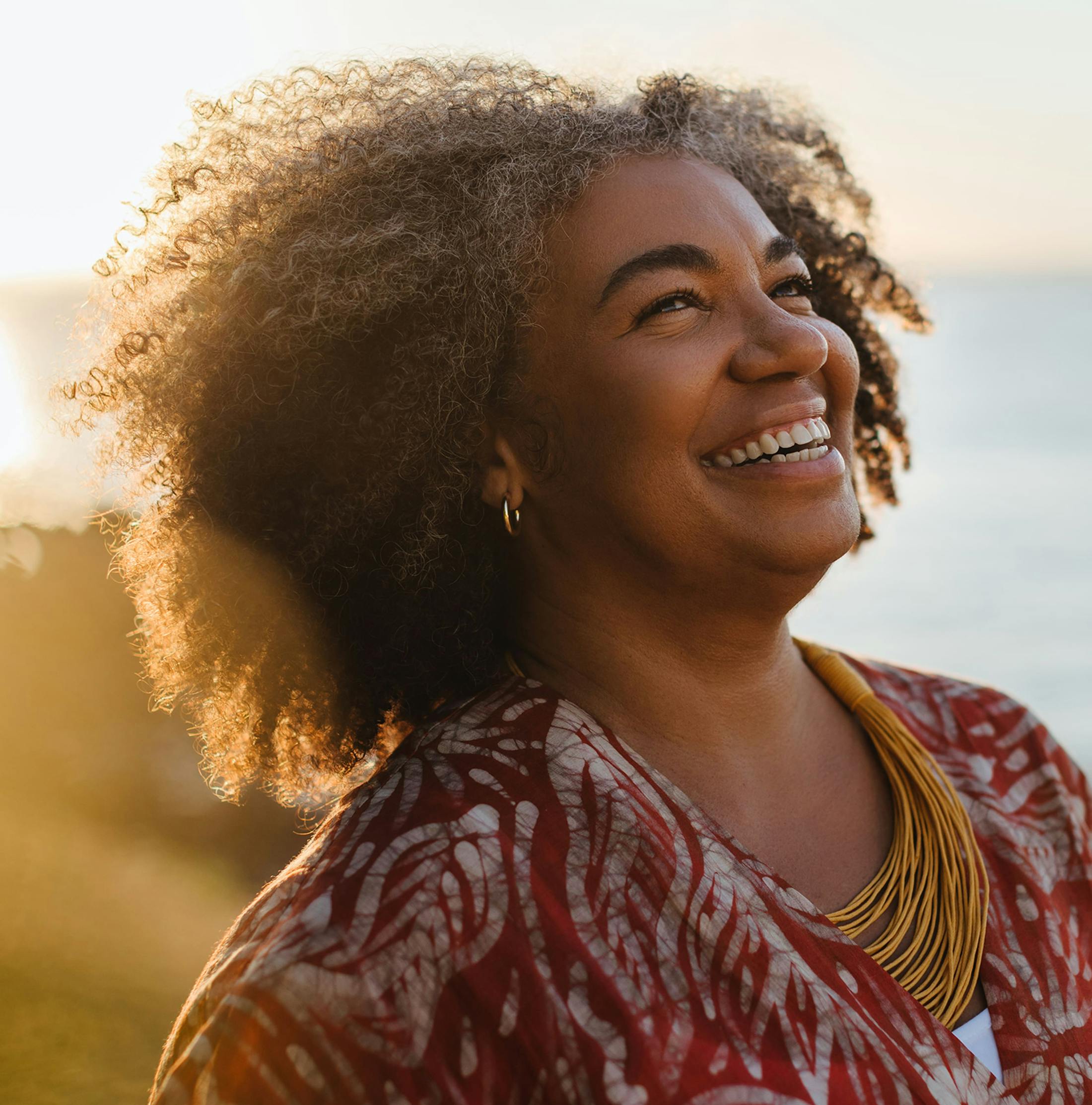 woman with afro smiling outside