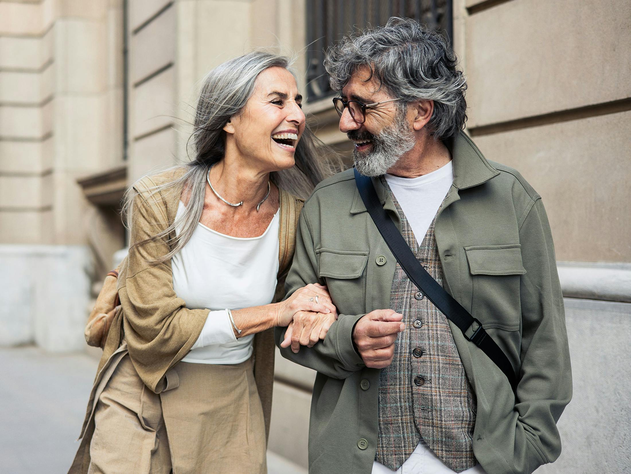 couple smiling and walking down city together