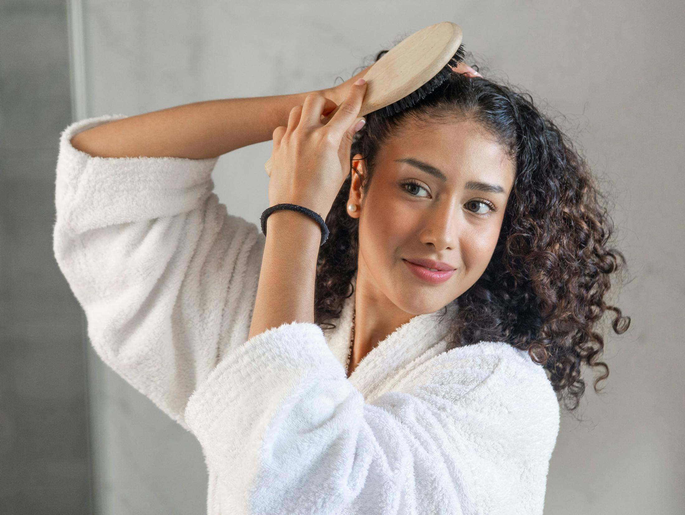 woman brushing her curl hair back