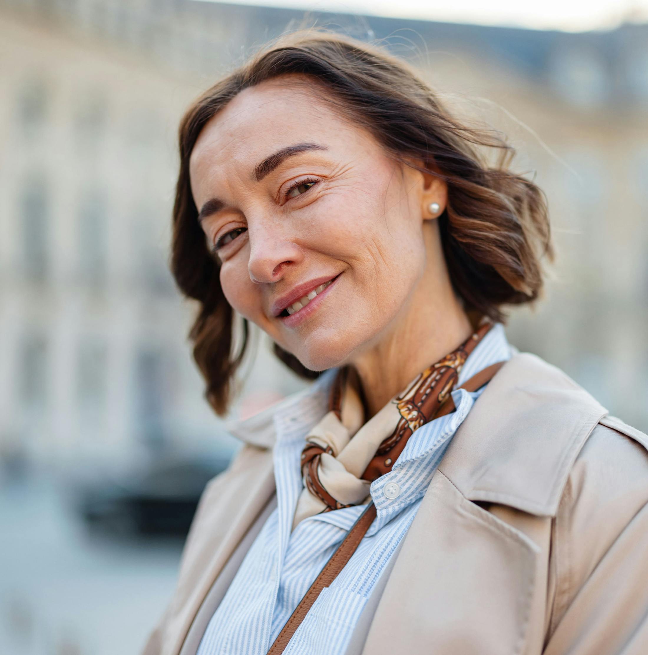 woman with short bob smiling and leaning her head forward