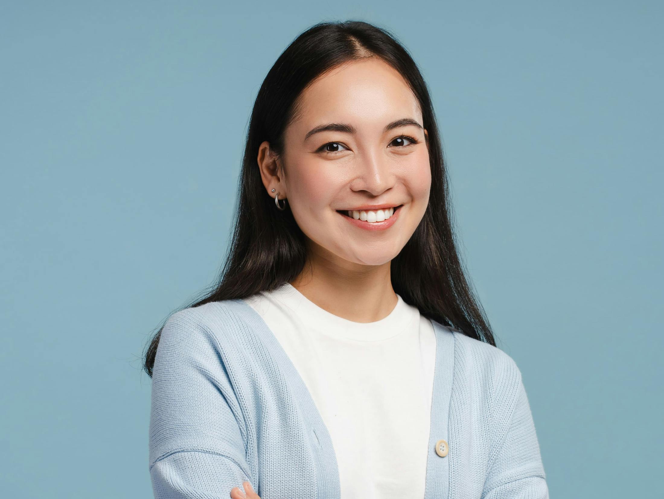 woman in light blue cardigan smiling