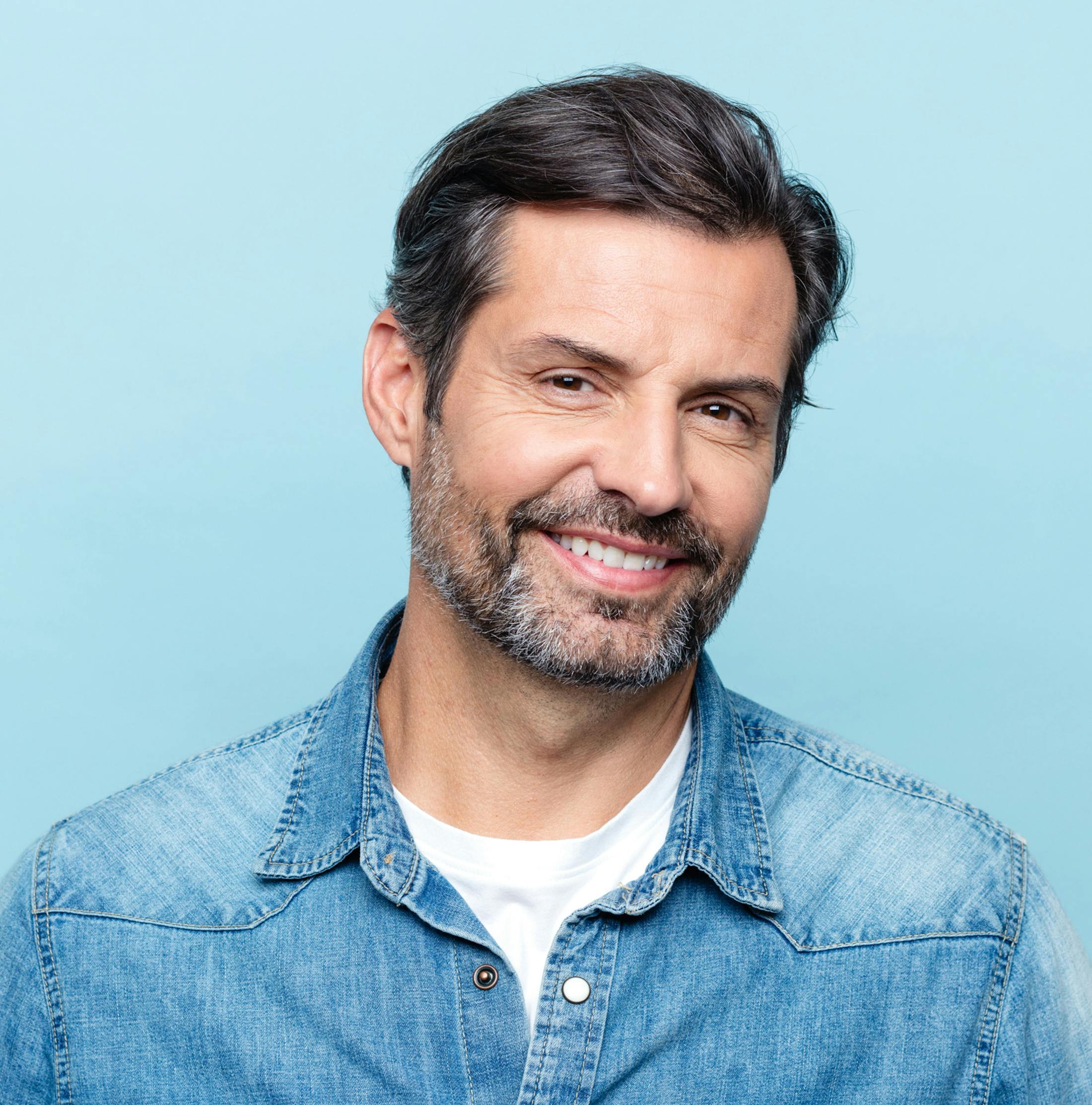 man smiling with jean jacket on
