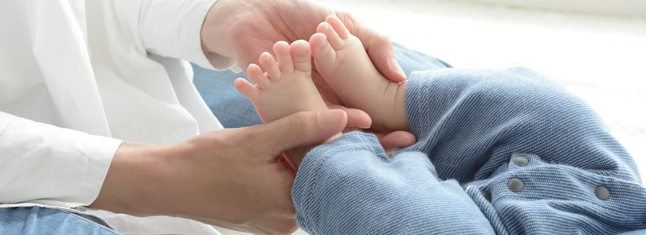 Baby feet being held by parent
