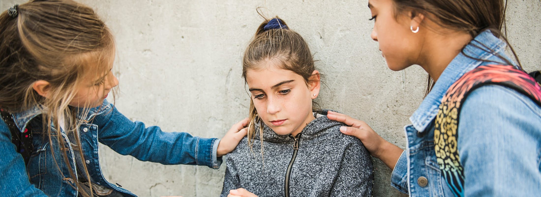 Upset girl being comforted by friends