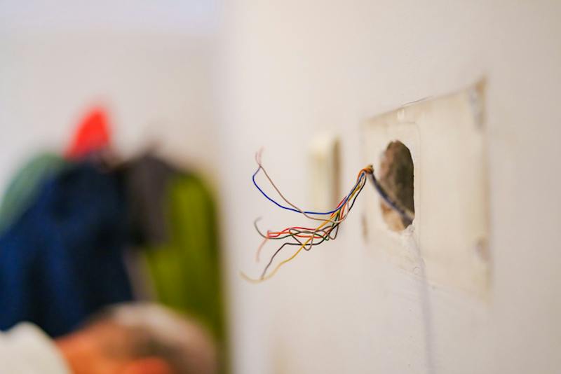 Open wire sticking out in apartment