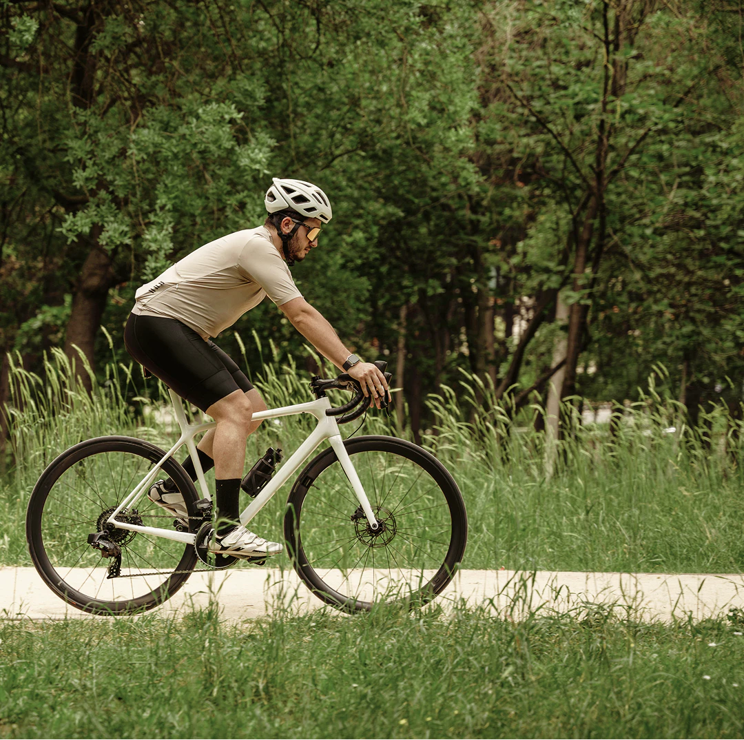 Man som cyklar i ett grönområde