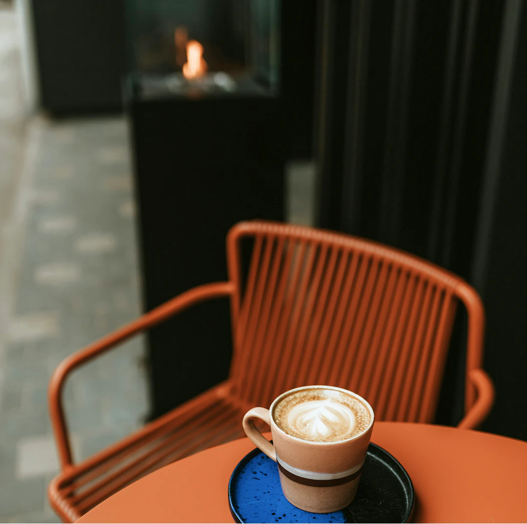 Kaffekopp på ett oreanget cafébord