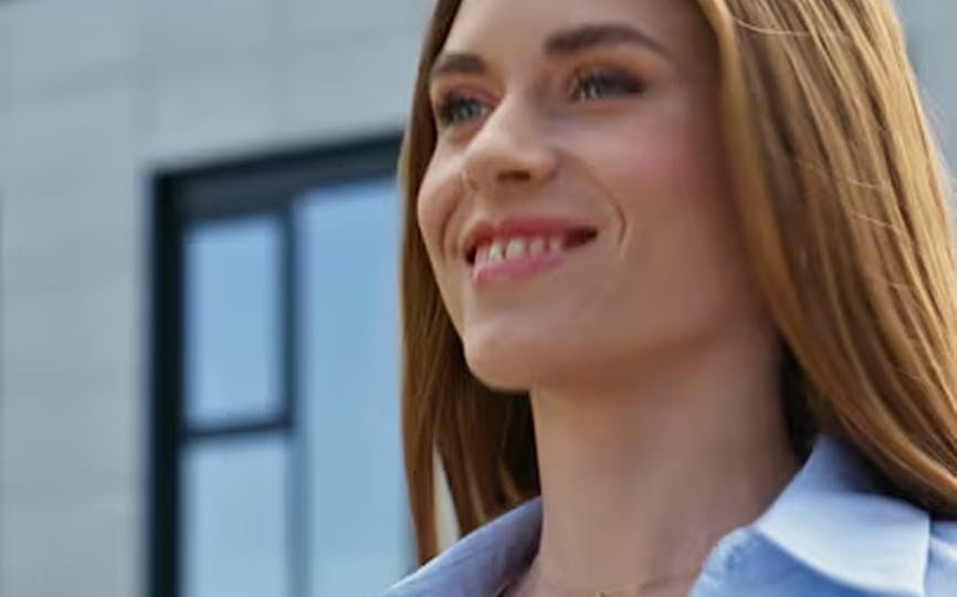 Smiling woman in blue shirt before facelift procedure