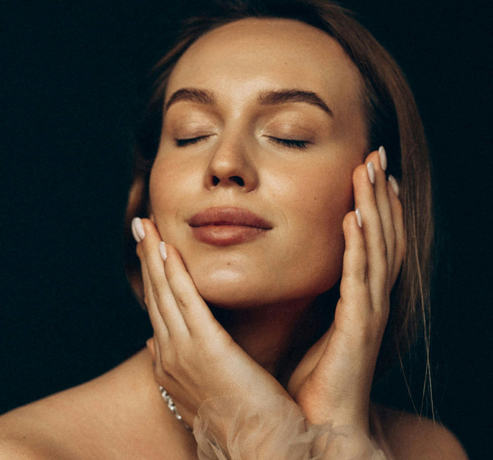 Woman touching her face with her eyes closed