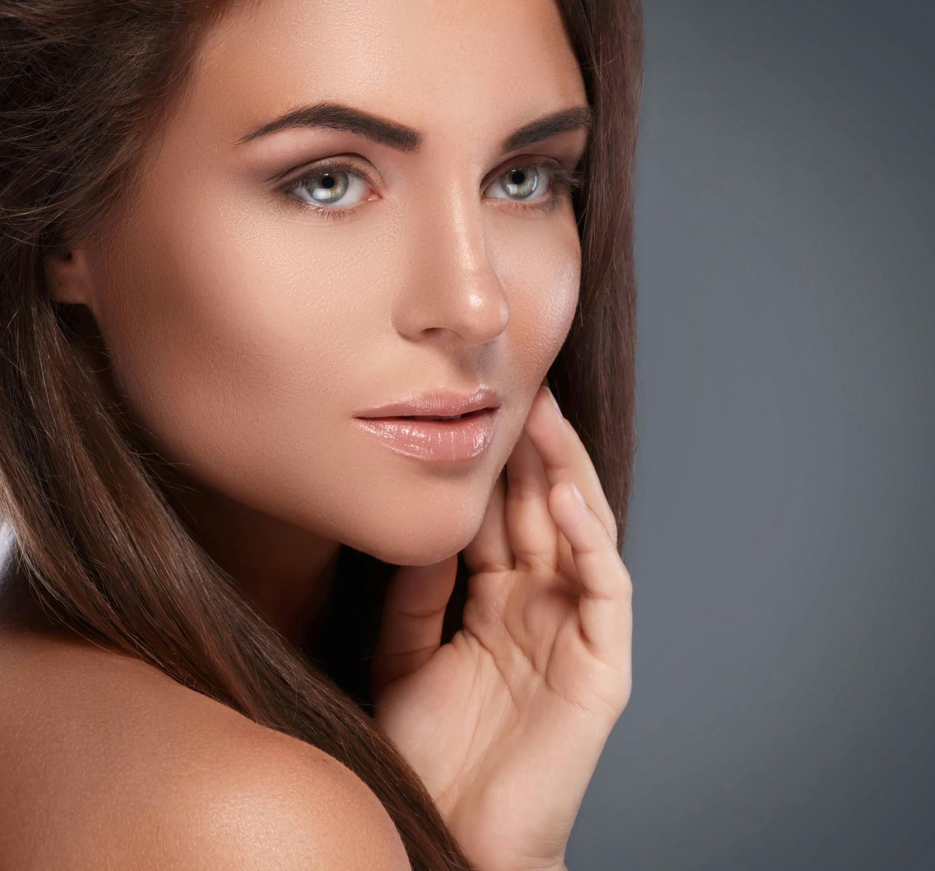 Woman touching face and looking over shoulder