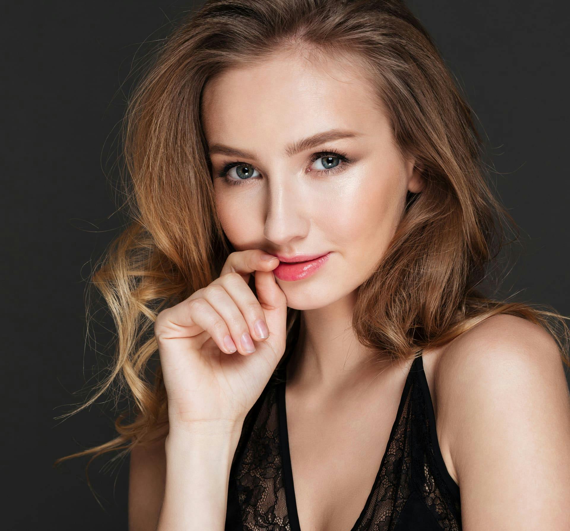 Woman smiling touching lips