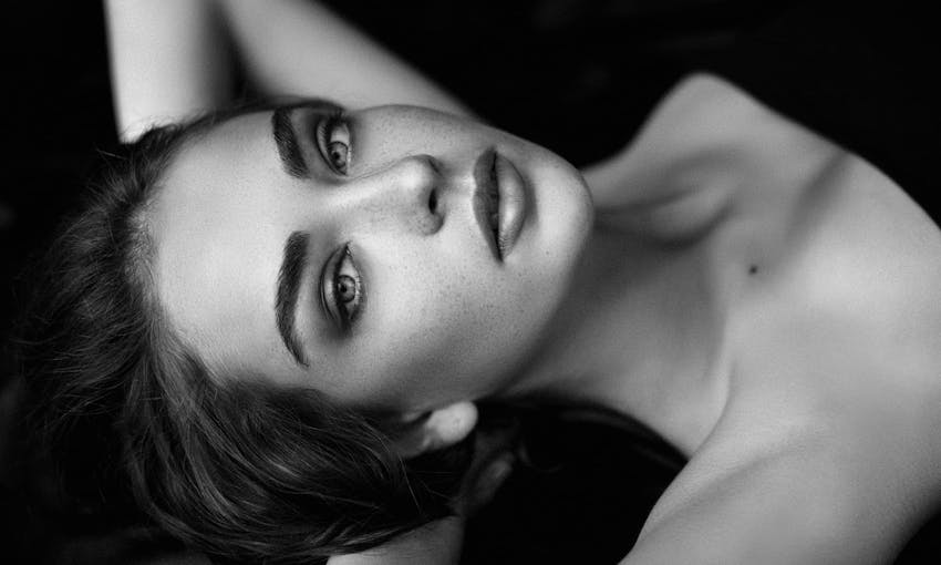 Woman laying down with hands behind head