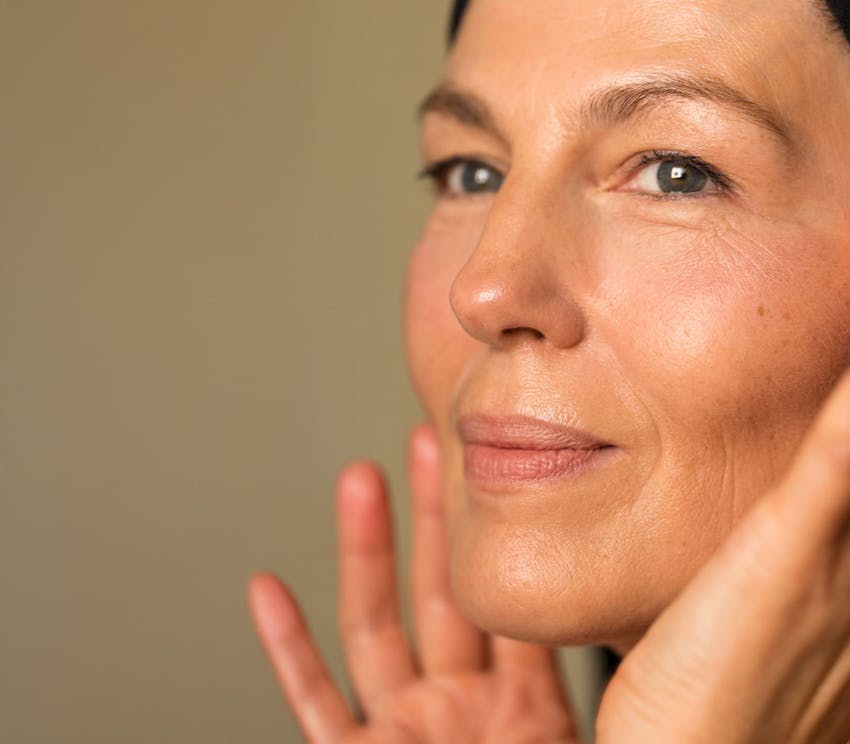 woman close up touching her cheeks