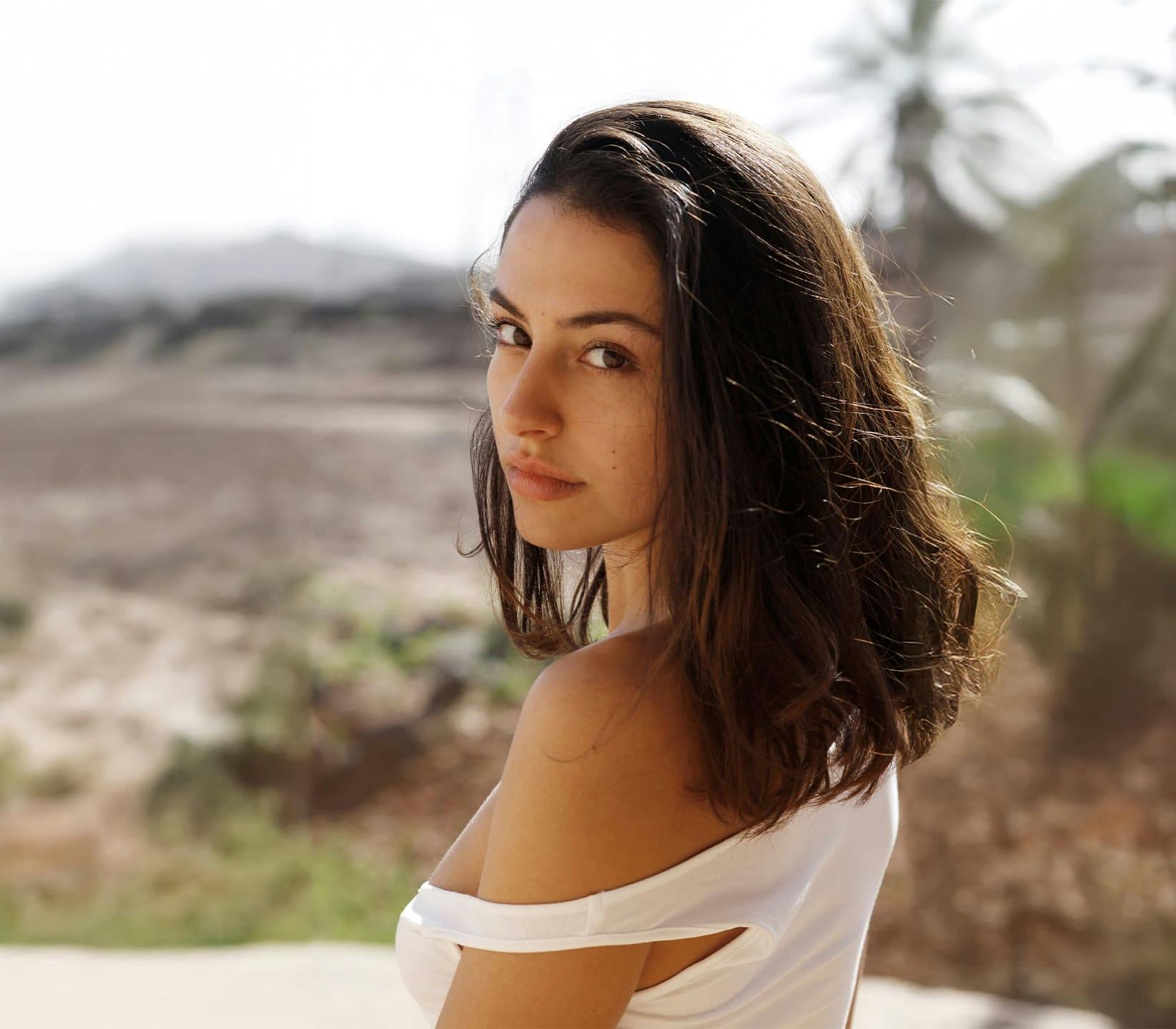 woman looking over her shoulder while being outdoors