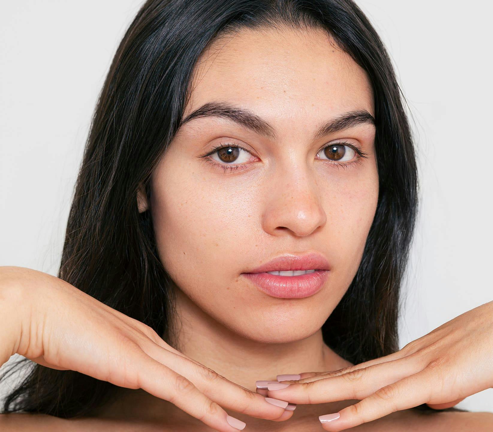 woman looking forward with her hands under her chin