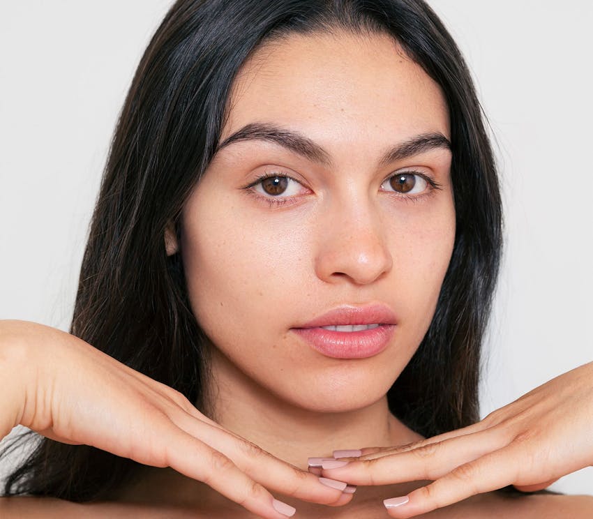 woman looking forward with her hands under her chin