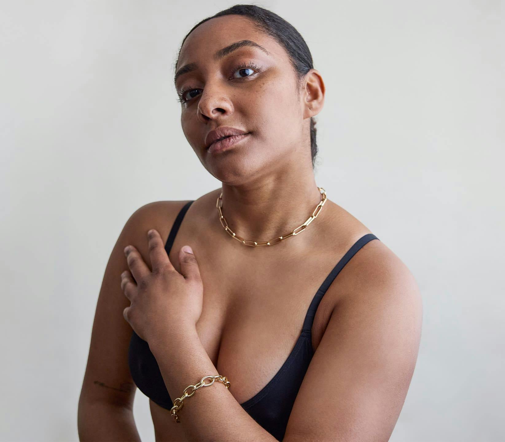 woman touching chest while wearing bra