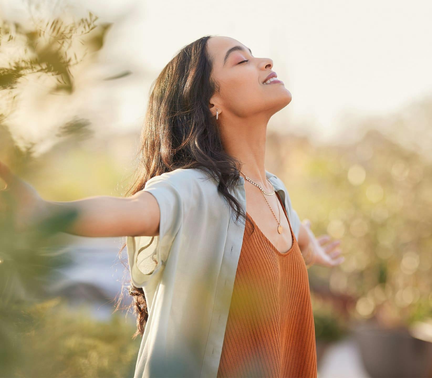 woman outdoors with her arms out