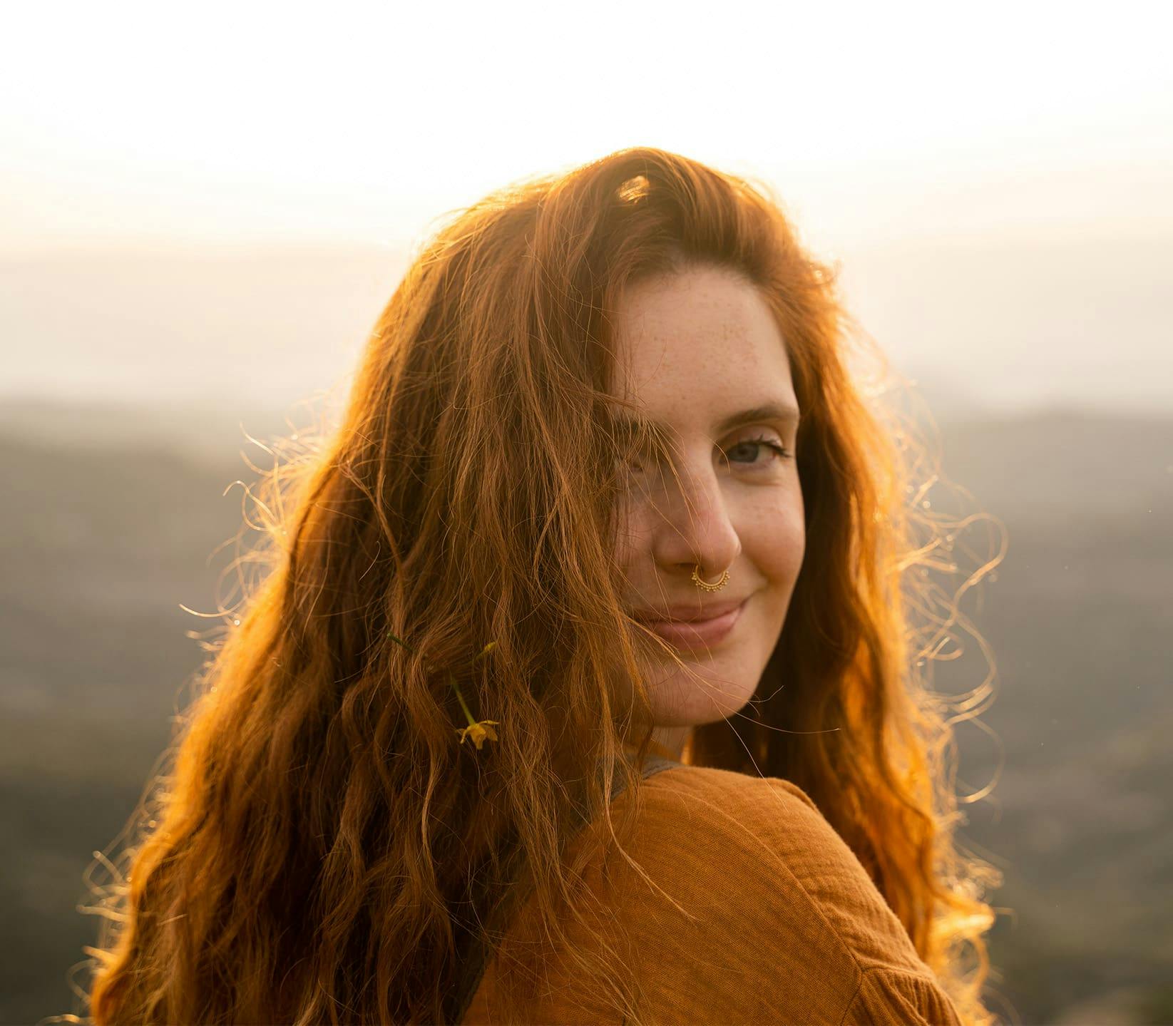 Woman looking over shoulder during sunset