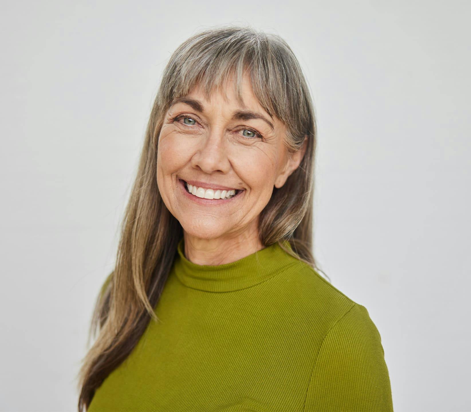 older woman smiling in green sweater
