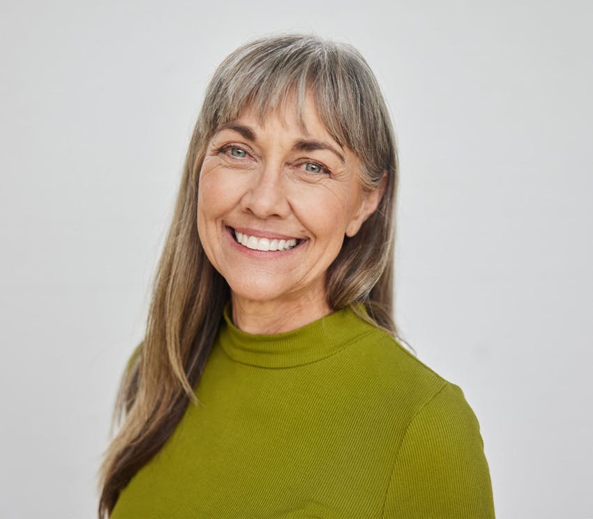 older woman smiling in green sweater
