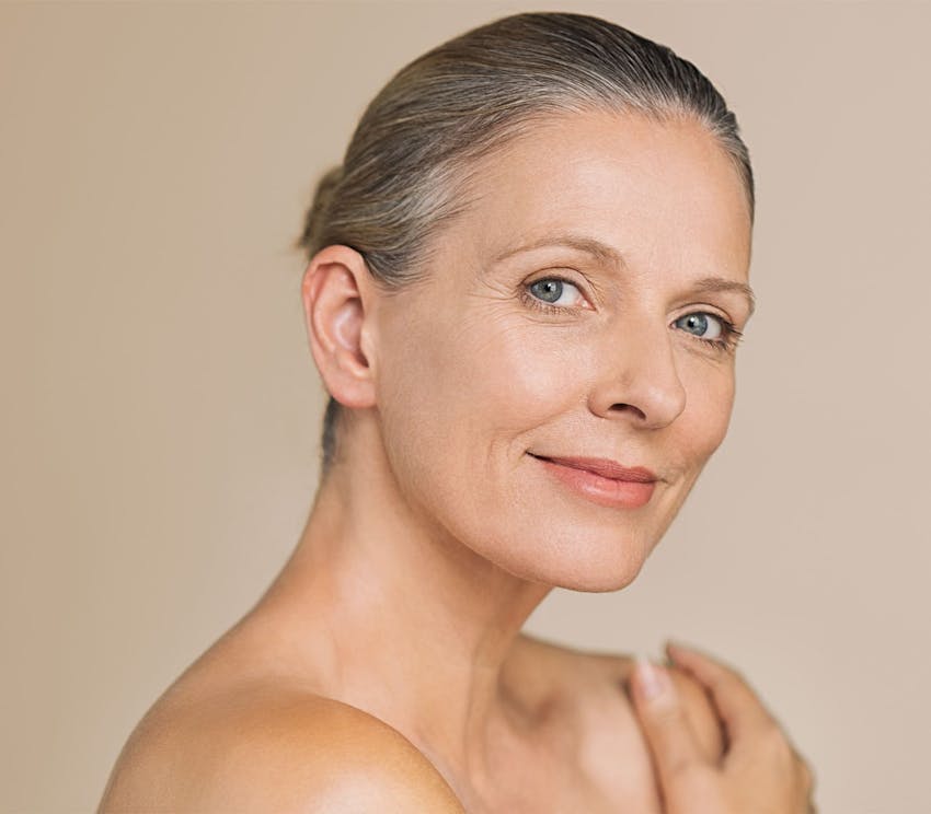older woman smiling with hair tied up