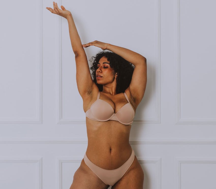 Woman in underwear with arms raised up