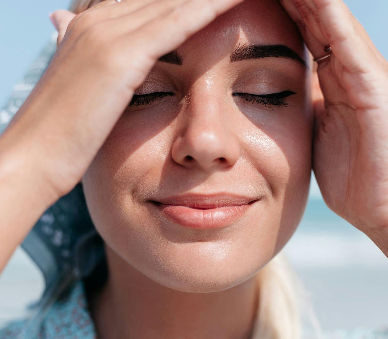 woman blocking the sun from her eyes with her hands