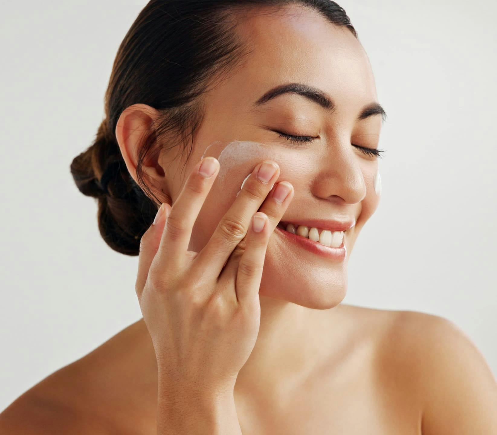 woman applying skincare to her cheek