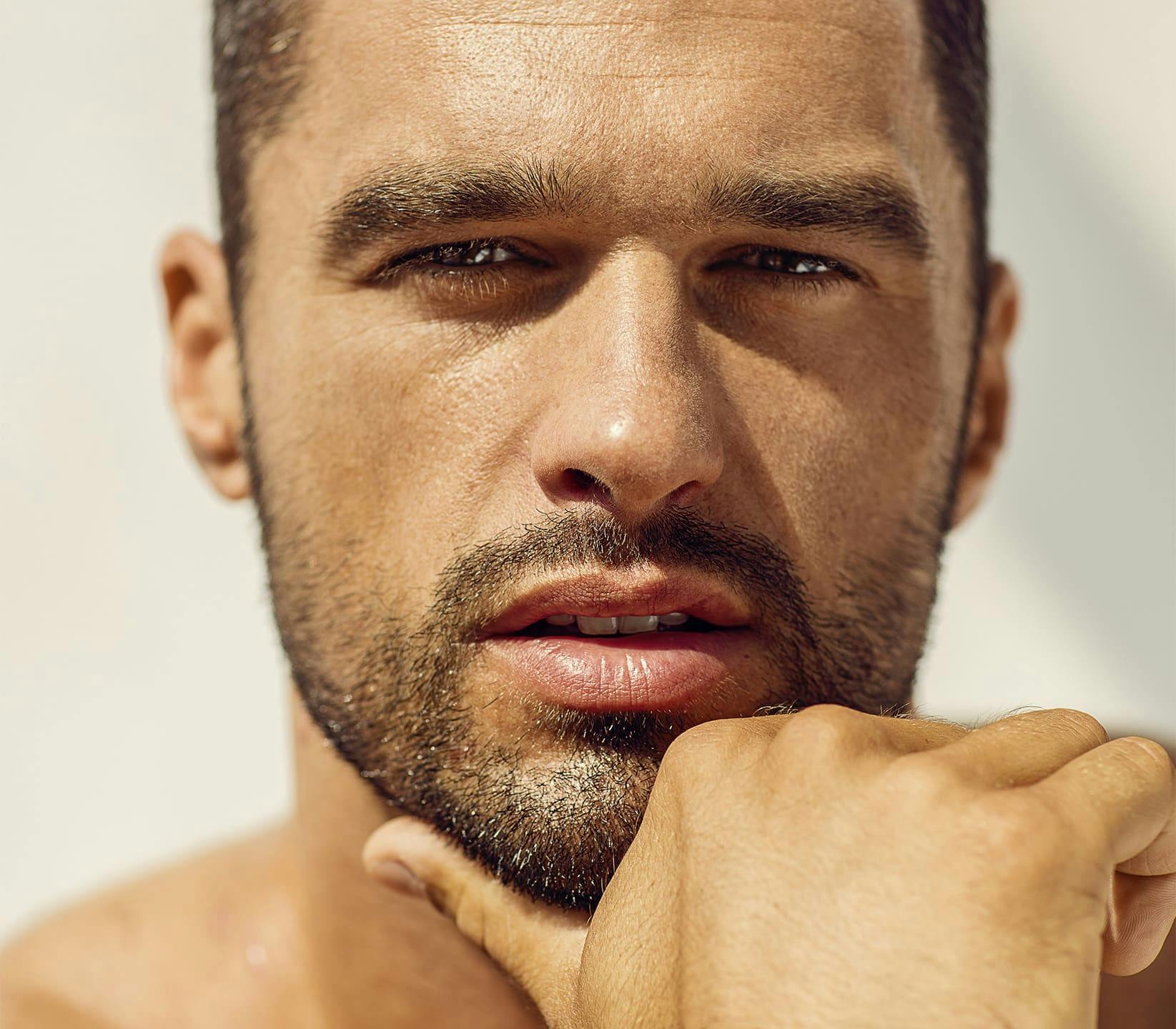 close up on man holding his chin with his thumb