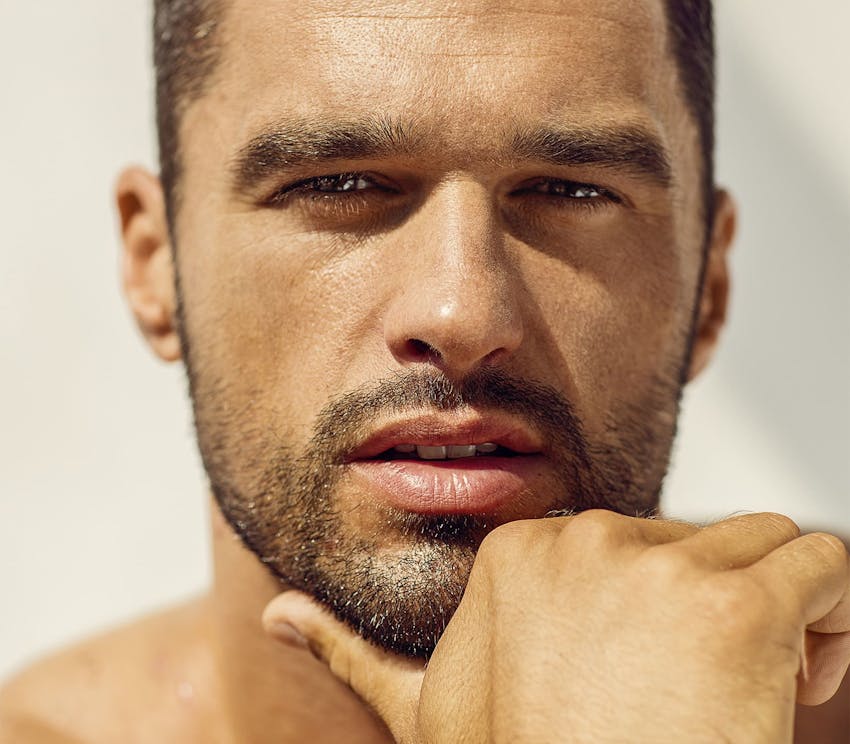 close up on man holding his chin with his thumb